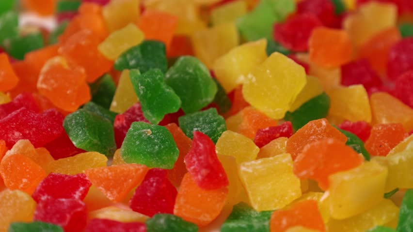 People enjoy colorful gummy candies at a festive event in a market setting during the afternoon hours