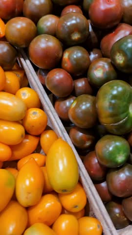 Fruit market display shows various types of tomatoes and other vegetables in bright colors
