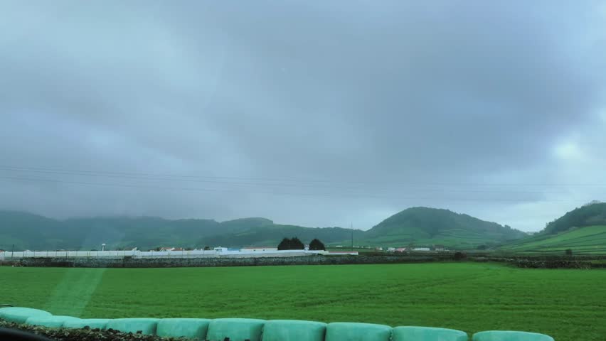 Green agricultural fields with hills under cloudy sky São Miguel Azores