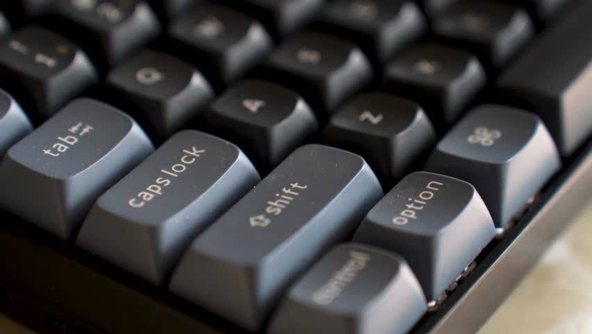 Close-up of Mechanical Keyboard with Red Enter Key. High-angle macro shot of a mechanical keyboard featuring black and grey keycaps with a distinctive red accent enter key