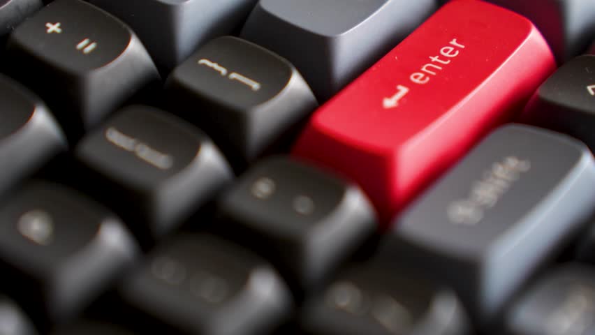 Close-up of Mechanical Keyboard with Red Enter Key. High-angle macro shot of a mechanical keyboard featuring black and grey keycaps with a distinctive red accent enter key