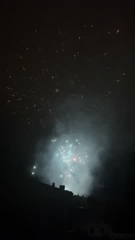 Colorful fireworks exploding in the night sky over a town