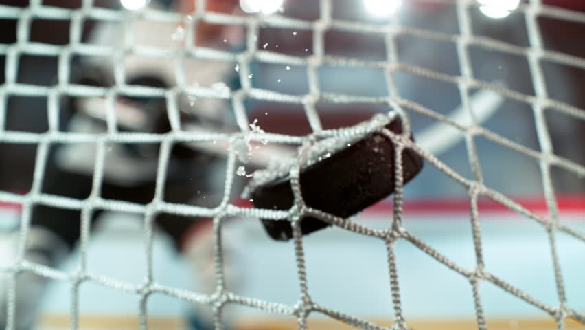 Super slow motion of ice hockey puck hitting the back of the net as it scores a goal