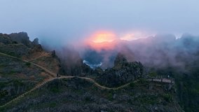 Mountains on sunset covered in fog and clouds with blooming Cytisus shrubs. Near Pico de Arieiro , Madeira island, Portugal. Push in approach dolly move - Powered by Shutterstock - Get 15% off with code: PIKWIZARD15
