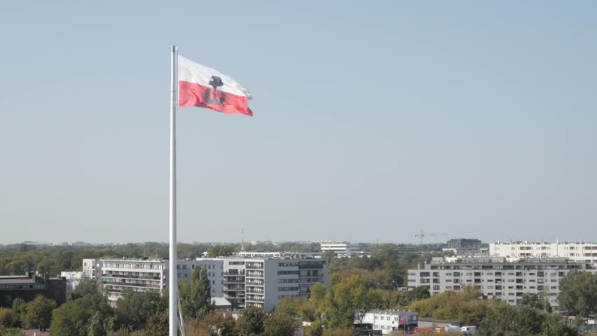 Polish flag with national emblem waving in Warsaw, symbolizing patriotism, historical pride, and the spirit of Poland’s resilience and national identity.
