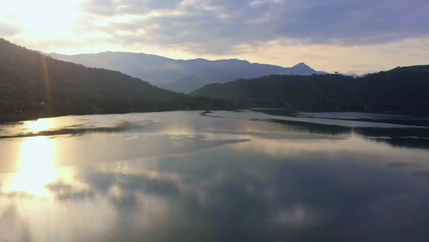 Experience serenity with this stunning lake landscape at sunset. Majestic mountains meet calm waters, creating a peaceful atmosphere perfect for relaxation, inspiration, or adventure