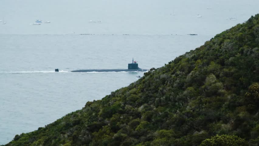 Telephoto shot of a U.S. nuclear submarine sailing out of San Diego Harbor, showcasing naval power, strategic defense, and maritime operations.