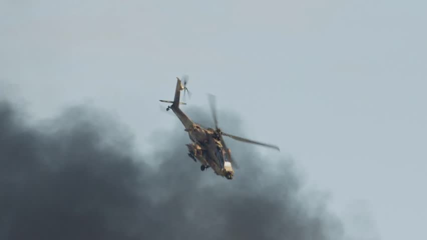 AH-64D Apache Longbow helicopter attacks targets with its cannon, showcasing military firepower, tactical air assault, and advanced combat aviation.