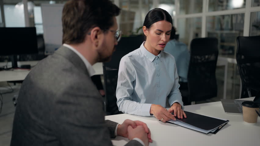 Two business people colleagues in office discuss papers. Caucasian businesswoman insurance agent loan bank worker woman consulting businessman client man buyer reading contract document invest consult