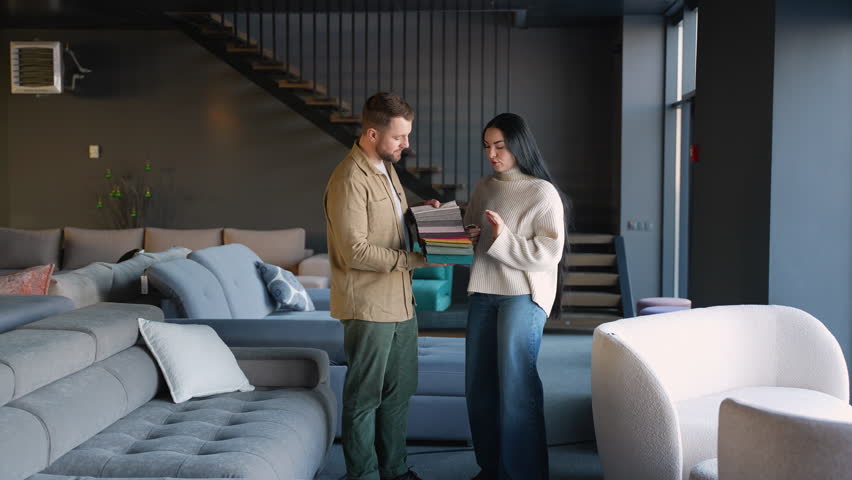 Couple choosing fabric color for a new sofa in a furniture store