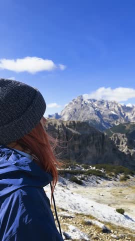 Woman enjoying mountain panorama overlooking Dolomites valley near Tre Cime.

Peaceful lifestyle moment of traveler admiring alpine scenery.