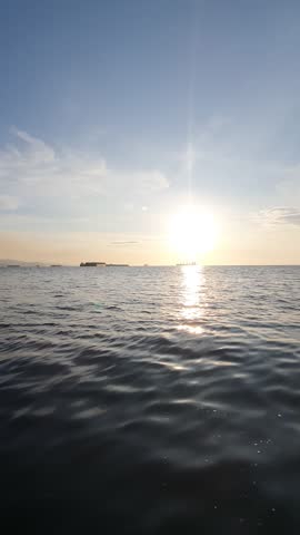 the sun is visible over the vast ocean