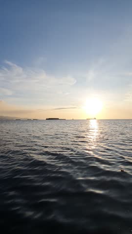 the sun is visible over the vast ocean