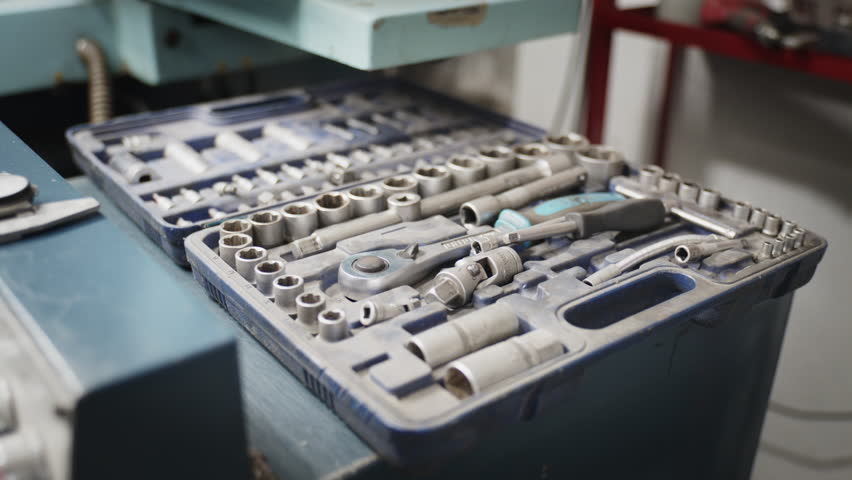 Slow pan of aprofessional socket and ratchet wrench set resting in a blue case in a workshop
