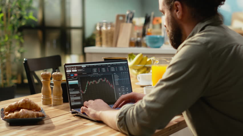 Financial trader at home, day trading fluctuations, monitoring market trends, candlestick charts on laptop used to check platform for investments. Stock exchange assets, crypto currency trade.