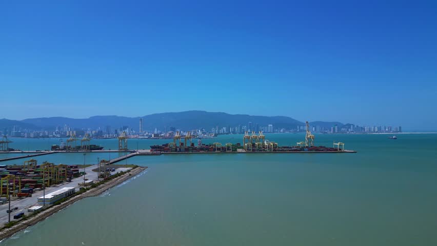Busy container port with stacks of shipping containers and gantry cranes, representing global trade and logistics. Wonderful aerial view rotation pan to left drone