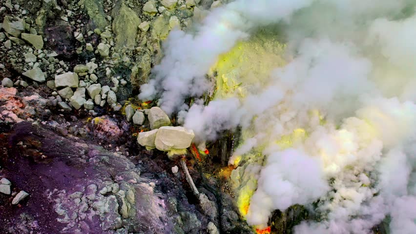 Aerial Shot at Active Volcano Fumaroles of Mount Ijen Where Yellow Sulphur Is Mined Amidst Grey Rocks. Large White Gas in Amazing Banyuwangi Regency of Java Island Indonesia Outdoors Travel Trip 4k