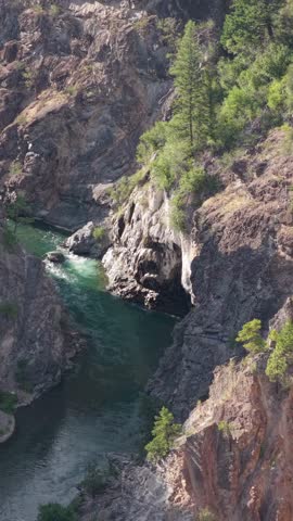 Discover the vibrant emerald waters of a river as it gracefully winds through a stunning canyon in British Columbia.