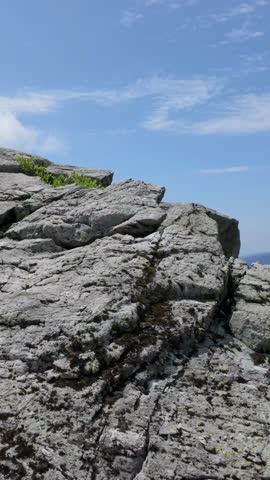 Panoramic view of a rugged, rocky mountain landscape in British Columbia, Canada, under a clear blue sky.