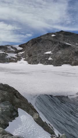 Stunning panoramic view of a pristine glacier and rugged mountains under a beautiful sky in British Columbia, Canada.
