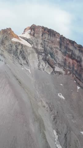 Grand mountain peak with a snow cap and evergreen trees in the wilderness of British Columbia, Canada.