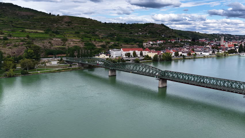Cinematic aerial drone shot of the historic Krems Bridge crossing the Danube River with the town of Krems an der Donau in Lower Austria at the entrance to the Wachau Valley.
