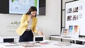 Happy interior designer speaking over the phone in her home office. Creative business woman taking notes during a phone call with her clients. Female designer working on a new project remotely. - Powered by Shutterstock - Get 15% off with code: PIKWIZARD15