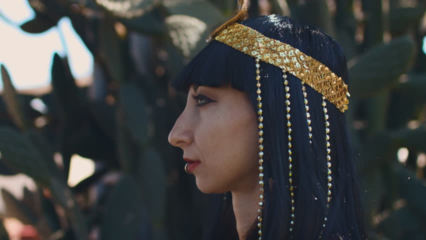 A girl at a carnival. A woman in a Cleopatra costume adjusts her accessories and prepares for the celebration. Purim holiday. Culture and traditions.