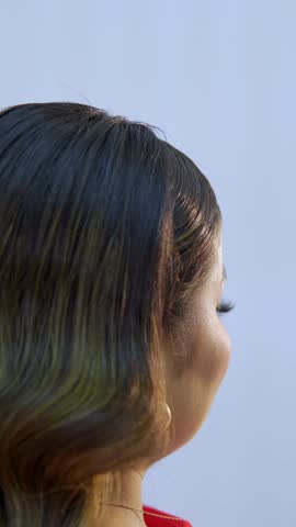 Young gorgeous woman with elegant makeup turning her head and smiling during a photo session