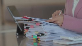 Close-up of a businesswoman reviewing a stack of organized documents with colorful tabs and clips at a desk, representing paperwork management, office organization, and administrative work. - Powered by Shutterstock - Get 15% off with code: PIKWIZARD15
