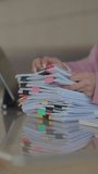 Close-up of a businesswoman reviewing a stack of organized documents with colorful tabs and clips at a desk, representing paperwork management, office organization, and administrative work. - Powered by Shutterstock - Get 15% off with code: PIKWIZARD15