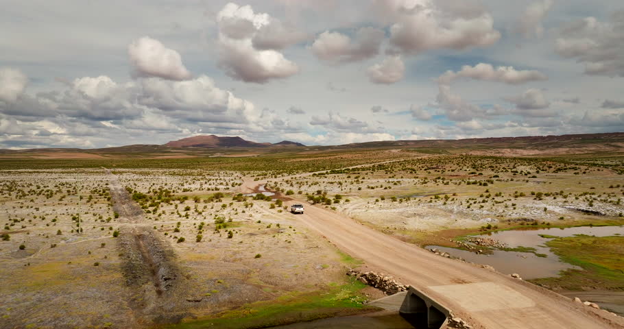 Panoramic Aerial View Of Pick-up Truck Traveling On A Dirt Road Through The Siloli Desert In Bolivia.