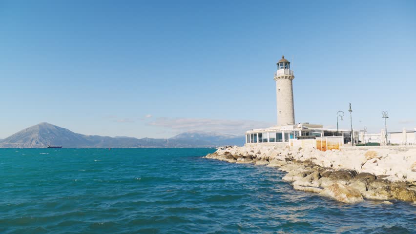 Patras Lighthouse on the coast of Patras Greece with sea and mountains in background