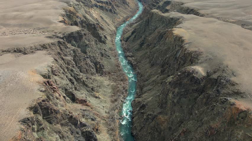 Majestic aerial perspective of the vibrant turquoise charyn river carving its way through the rugged, barren landscape of black canyon in kazakhstan