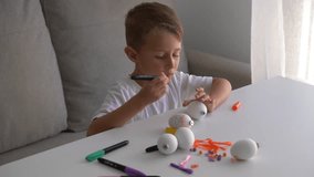 Little boy painting Easter eggs with colorful marker at home. Kid doing creative holiday craft activity and preparing handmade Easter decorations. - Powered by Shutterstock - Get 15% off with code: PIKWIZARD15