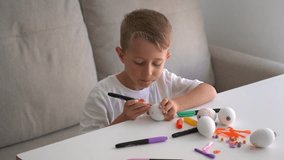 Little boy decorating Easter egg with marker at table. Child doing creative holiday craft activity and preparing handmade Easter decorations at home. - Powered by Shutterstock - Get 15% off with code: PIKWIZARD15