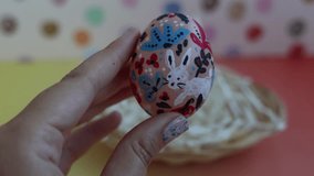 Handmade Easter Egg with Bunny and Floral Painting. Close-up of hands gently holding a beautifully hand-painted Easter egg featuring a charming white bunny and colorful floral designs. Perfect for conveying the joy of handmade Easter decorations and springtime festivities. - Powered by Shutterstock - Get 15% off with code: PIKWIZARD15