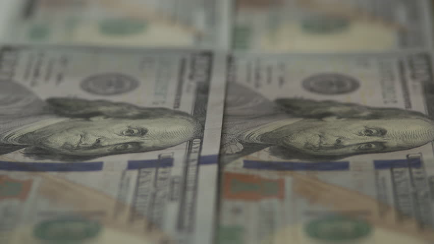 Macro view of US one hundred dollar banknotes arranged in rows, highlighting Benjamin Franklin portrait and symbolizing finance, wealth, and economy.