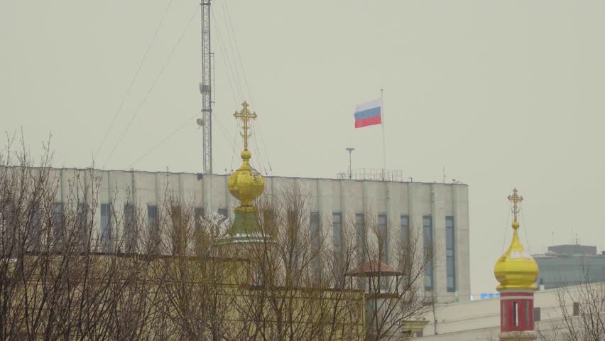 Russian Flag Over City Skyline With Orthodox Church Golden Domes and Government Buildings.