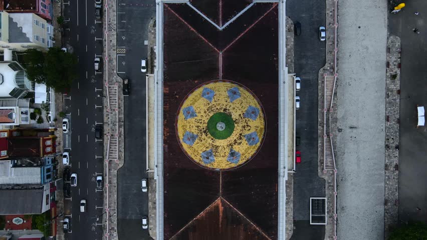 Teatro Amazonas and Largo de São Sebastião square in Manaus, Brazil during cloudy afternoon. Top-down aerial ascent over the theatre roof with cars passing by on street. 4K wide.