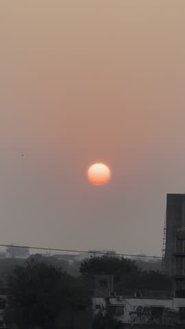 A unique celestial moment where the rising sun and the fading moon appear together in the early morning sky. The image captures the peaceful transition between night and day with warm sunrise tones and a soft blue atmosphere, highlighting the beauty of nature and astronomy.