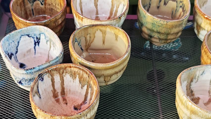 Handmade ceramic tea set with unique textured glaze on a decorative tray.