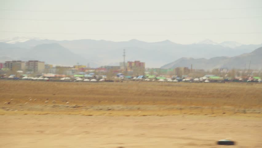 Colorful Town Passing By Landscape. Scenic View Of Town On Dry Plains. Vibrant Town Scene With Distant Mountain Foothills. Bright And Lively Townscapes Seen From Window Over Arid Terrain