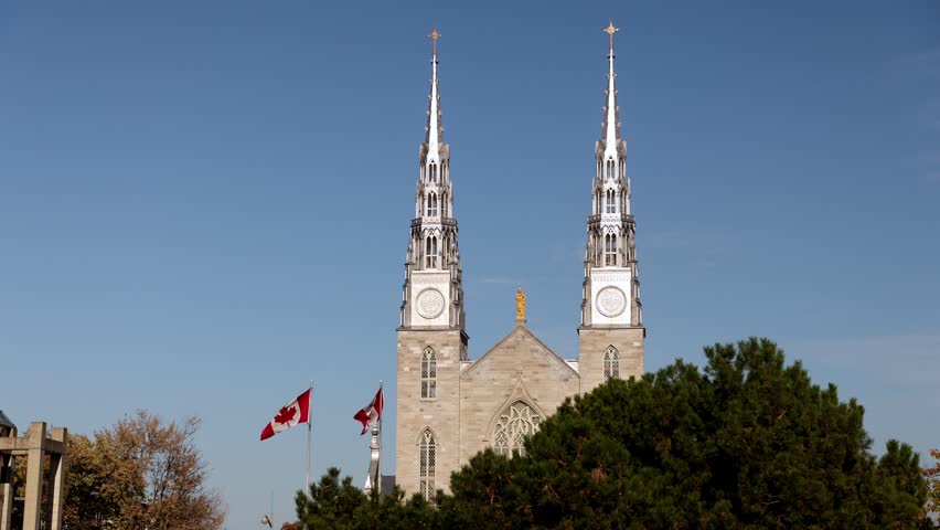 Notre-Dame Cathedral Basilica in Ottawa with Canadian flags. Gothic Revival church architecture in national capital city