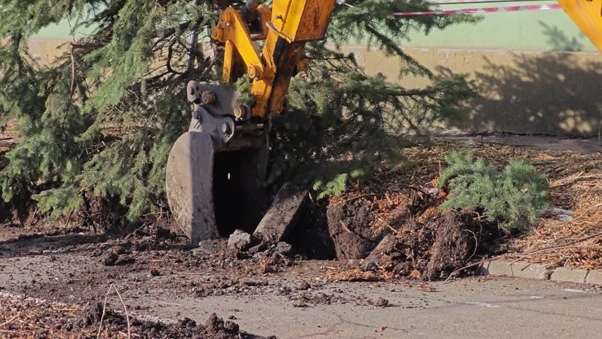 Excavator bucket digging into earth at construction site