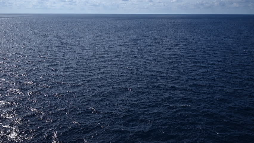a vast, tranquil seascape under a bright, expansive sky.