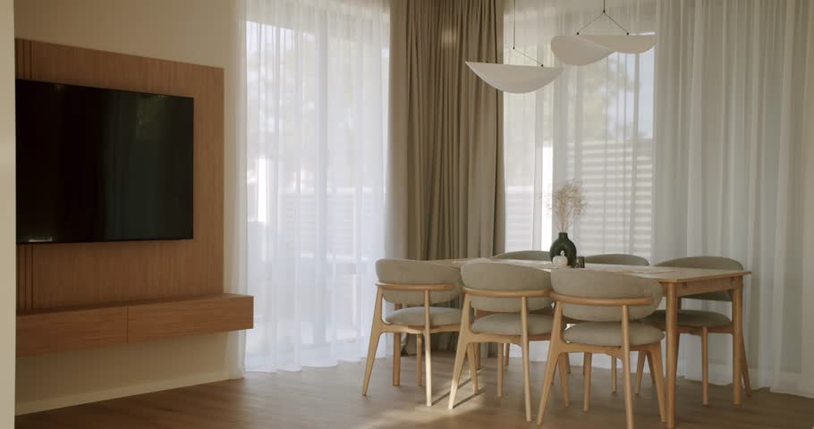 Bright and spacious dining room with a wooden table, minimalist chairs, and a large window with sheer curtains, creating a calm and inviting atmosphere for contemporary living