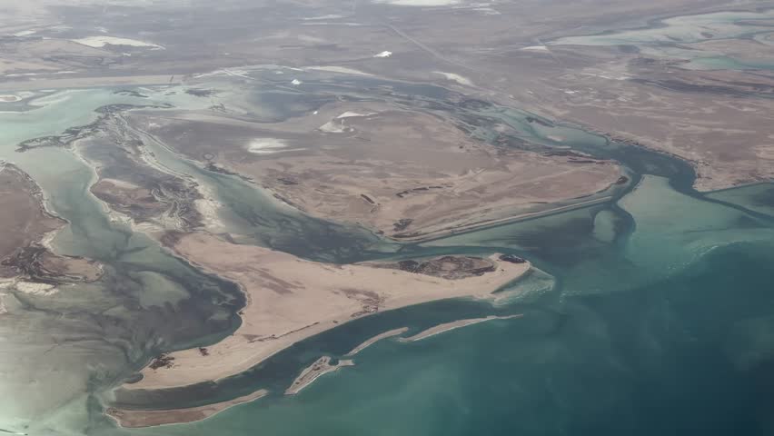 4k aerial video footage, flying along United Arab Emirates coastline near Abu Dhabi - the capital of the Emirate of Abu Dhabi while passing Al-Aryam Island, Halat Al Bahrani and Al Fteysi Island with deserts in the background 