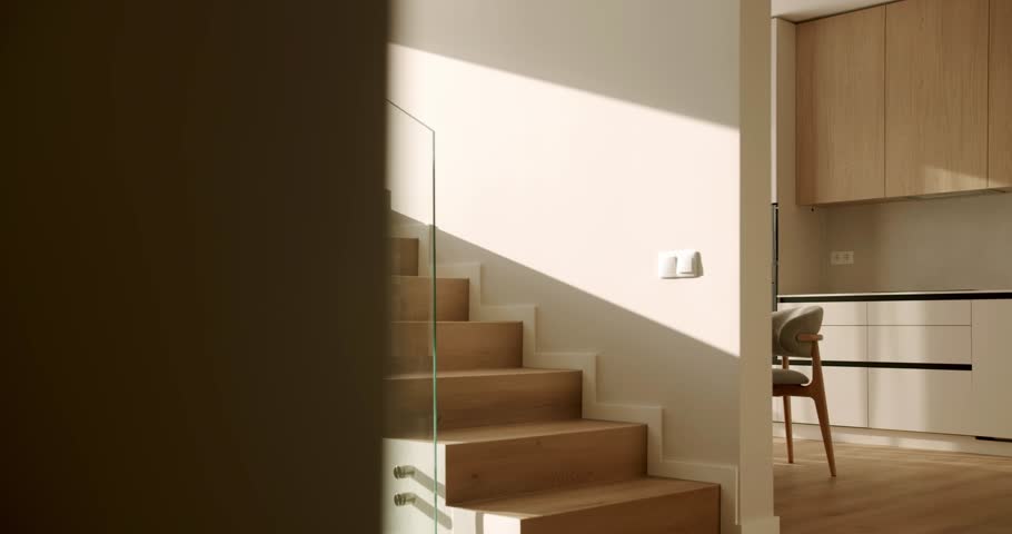 Timelapse of sunlight and shadows moving across a stylish wooden staircase with a glass balustrade in a contemporary minimalist home, showcasing elegant architecture and modern interior design
