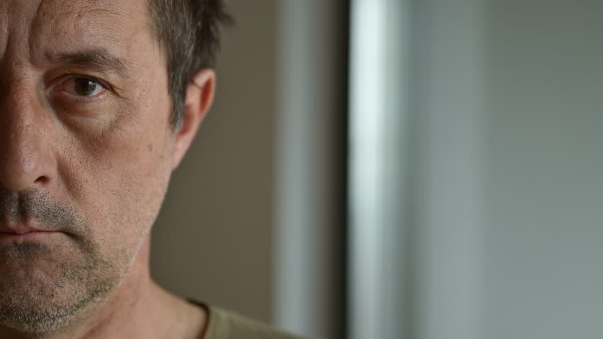 Half face portrait of serious mature adult caucasian male looking at camera, 4K selective focus